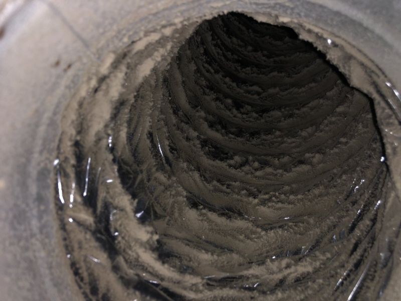 Construction-era debris visible inside a residential air duct before cleaning